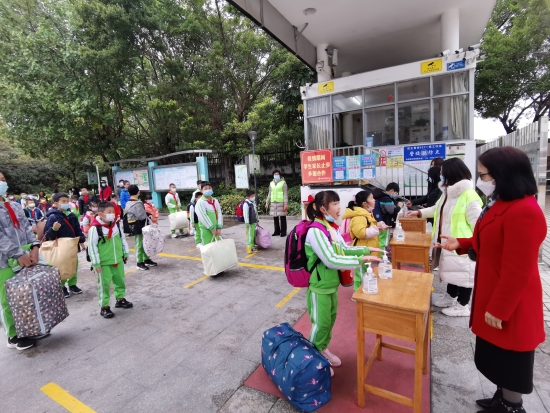已處理10  沙坪六小的同學們保持1米線距離在校門口進行手部消毒，有序進校園.jpg